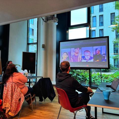 person watching a large screen showing 3 other webmeeting participants.