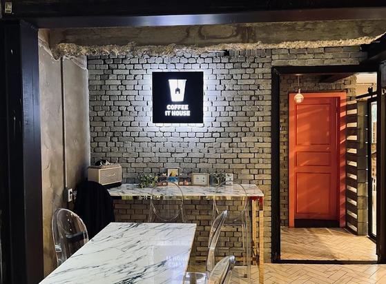 A cozy coffee shop interior with exposed brick walls and modern marble tables.