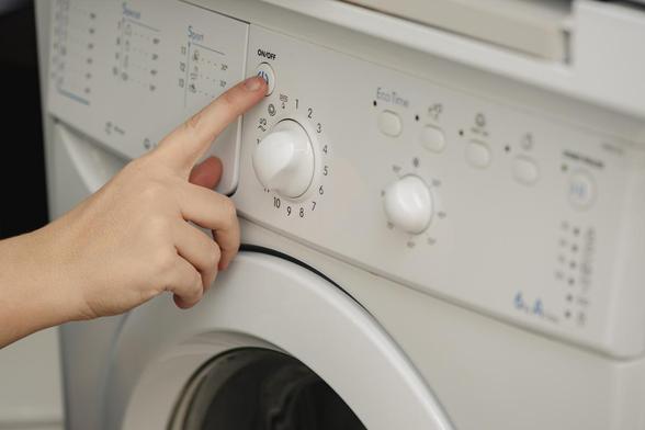 Una persona apretando uno de los botones de la lavadora. (Getty Images)