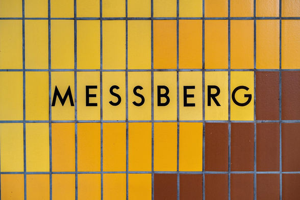 Foto der gekachelten Haltestellen-Wand mit dem Schriftzug "MESSBERG"