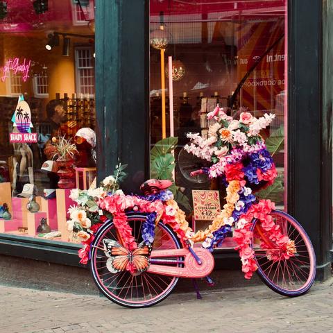 a pink bicycle decorated with flowers in front of Shady Shack