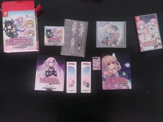 starting top left: Package of the order, a sticker of the game, 4 acrylic character stands (nepgear, uni, rom, ram), OST as a CD, the switch game package itself
second row: limited edition certificate (lol), two vertical stickers each with two characters(nepgear/uni, rom/ram), small case for the game card, art book