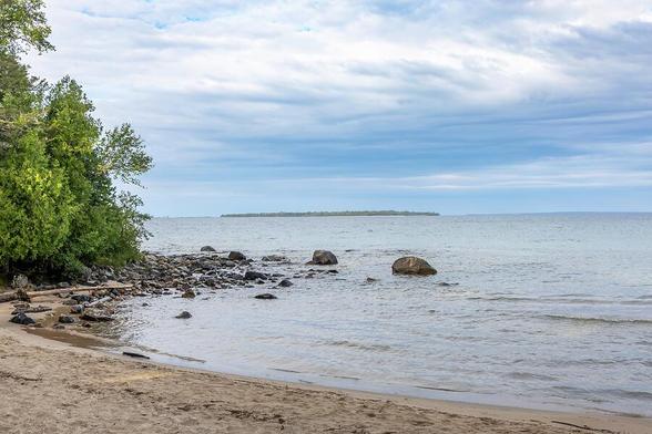 Katherine Cove offers a tranquil escape with its pristine sandy shores and lush forest backdrop along Lake Superior.