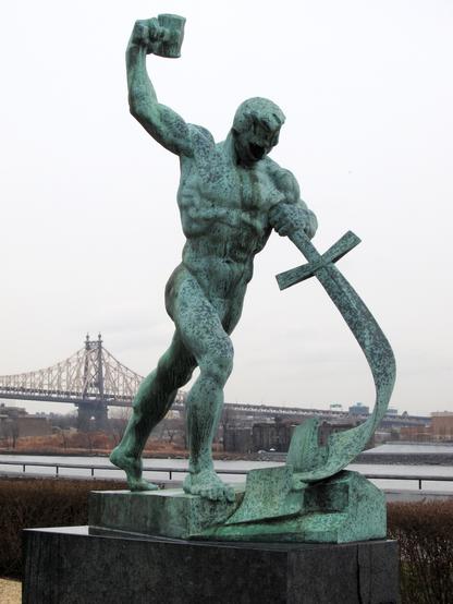 Let Us Beat Swords into Plowshares, a sculpture by Evgeniy Vuchetich in the United Nations Art Collection. Shows a burly man swinging a hammer into a sword. By Neptuul - Own work, CC BY-SA 3.0, https://commons.wikimedia.org/w/index.php?curid=32412758