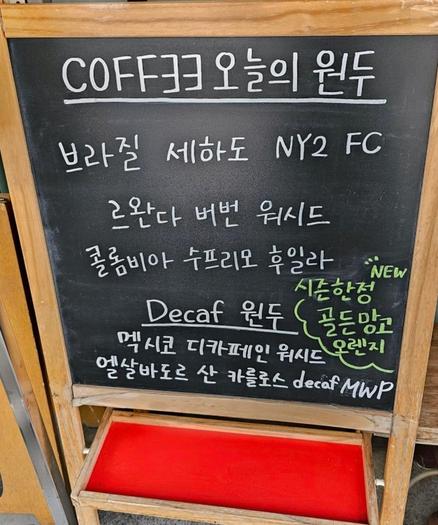 A chalkboard menu with the words "COFF∃∃ 오늘의 원두" (Coffee Today's Beans) at the top, followed by a list of coffee bean origins.