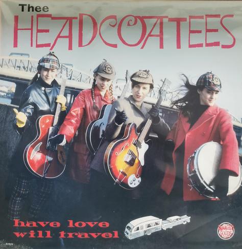 LP cover of Have Love Will Travel by Thee Headcoatees. Cover shows the 4 band members holding musical instruments standing in front of a wall with a bridge crossing a river in the background.