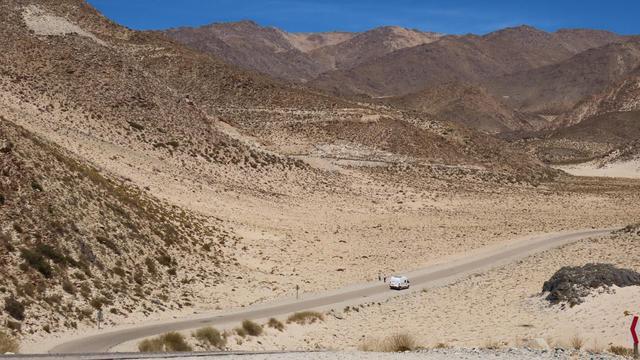 Berge und die bewachsenen Dünen. Ganz klein ein Wohnmobil auf der Ruta