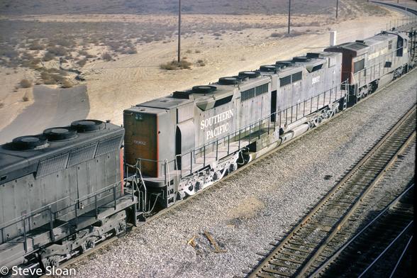 Southern Pacific (SP) 9902 heads west under Pepper Avenue in West Colton, CA on Saturday, December 29, 1973.