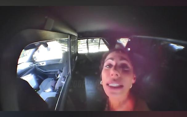 Face of an impaired white woman in back of cop car