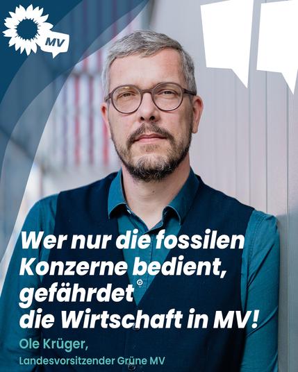 Ole Krüger (graue Haare, Bart und Brille) steht vor einer hellen Wand und blickt ernst in die Kamera. Links oben ist das Logo der Grünen Mecklenburg-Vorpommern zu sehen. Daneben steht in weißen und türkisfarbenen Buchstaben das Zitat: „Wer nur die fossilen Konzerne bedient, gefährdet die Wirtschaft in MV!“ Darunter: „Ole Krüger, Landesvorsitzender Grüne MV.“