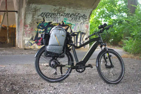 Aventon Level electric bike under a bridge with graffiti behind it, taken in Reading, PA on July 29, 2021.