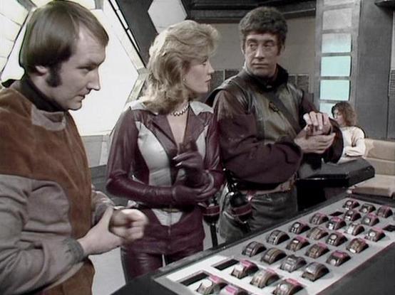 Claude Sonnet 4.0 describes the image as: "This appears to be a scene set aboard a spacecraft, likely the Liberator, showing crew members gathered around what looks like a control console or computer interface. The setting has the characteristic futuristic interior design of the series, with metallic surfaces and technological equipment visible in the background. The characters appear to be examining or discussing something displayed on a screen or panel, which shows a grid of what might be data or images. The scene has the typical dramatic lighting and composition of the series, suggesting this is likely from a moment where the crew is analyzing information or making an important discovery during their mission."

Blakes7Bot, version 3.9.33.
