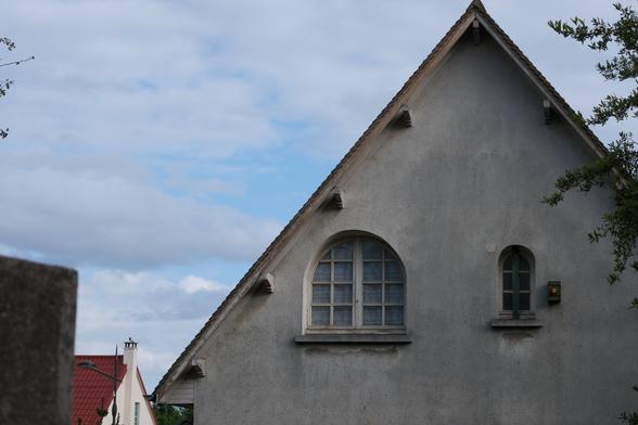 Front of a house with a window and another smaller one on the right next to it
