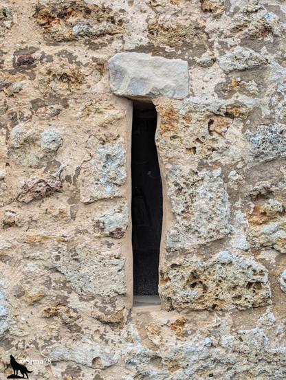 Meurtrière - ouverture étroite en forme de fente verticale dans un mur de pierre ancienne.
Arrow slit – a narrow vertical slit-shaped opening in an old stone wall.
Aspillera – una abertura estrecha en forma de rendija vertical en un muro de piedra antigua.