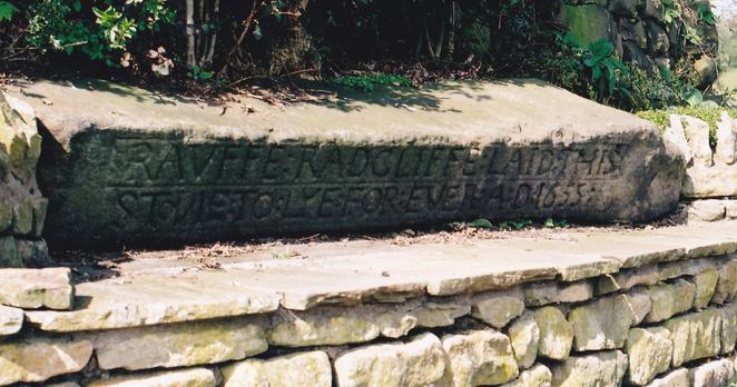 My photo of the Written Stone (does it always lie in shadow?). The inscription reads: 'RAUFFE RADCLIFFE LAID THIS STONE TO LYE FOREVER AD 1655'. It's been suggested the stone started life as a prehistoric standing stone. There are a number of tales of ancient stones being moved, only for the mover being forced to return it by invisible forces or recurring bad luck.