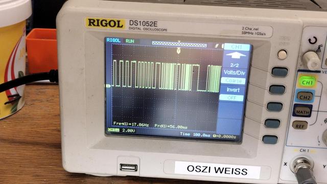 Bildschirm eines Oszilloskops mit einer gelben Linie die in unregelmäßigen Abständen rauf und runtergeht.