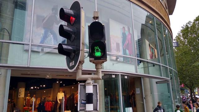 A pedestrian traffic signal showing green and displaying a rounded cartoon rabbit.