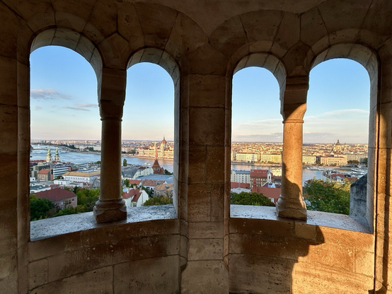 Scenic view of Budapest city including view of the parliament and the river Danube. View through four arched granite windows with no glass.
