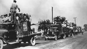 Caravan of migrant cotton pickers, San Joaquin Valley, California, 1933. signs on sides of vehicles read: Don't Scab.