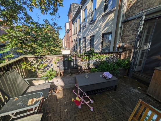 A picture of the whole thing with some children's toys in the foreground and a number of row houses in the background.

It's a cedar box along the whole side of the balcony with a number of plants in it.

From left to right are:
A grapevine
Mint
The compost bin
Strawberries
Parsley
Basil
The water barrel