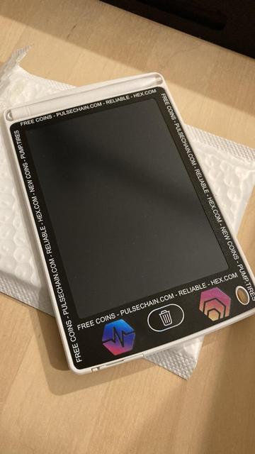 A “lcd device” with a pen. The text around the edges goes “FREE COINS - PULSECHAIN.COM - RELIABLE - HEX.COM - NEW COINS - PUMP.TIRES FREE COINS - PULSECHAIN.COM - RELIABLE - HEX.COM FREE COINS-PULSECHAIN.COM - RELIABLE - HEX.COM - NEW COINS - PUMP. TIRES FREE COINS - PULSECHAIN.COM - RELIABLE - HEX.COM”