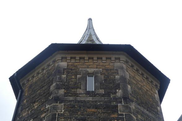 A tower with a small window in a Victorian Gothic building
