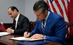 Hegseth signing the document: