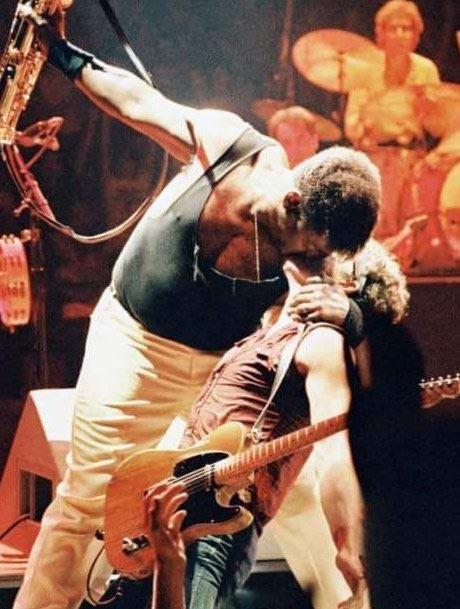 clarence clemons, the saxophonist for springsteen’s e street band, dips bruce and kisses him deeply on stage