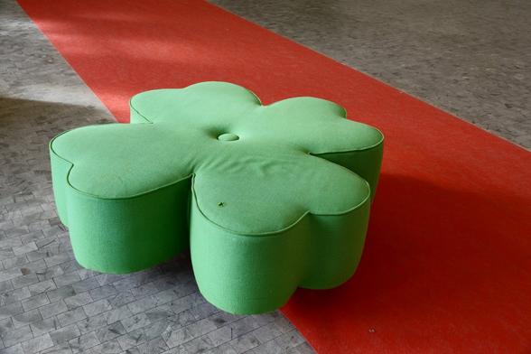 A clover-shaped chair on a red carpet