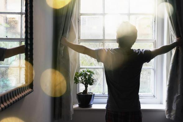 Una persona descorriendo las cortinas. (Getty Images)