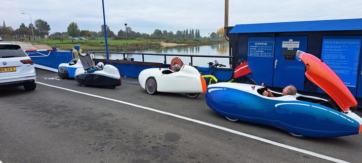Vier velomobielen en een tweewielligfiets op het pontje bij Wijhe.