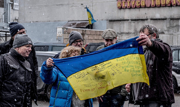 Picture from another trip to Kyiv. Volunteers from the organization are admiring the "thank you" flag they received from Ukrainian Special Operations Forces. A very special occasion.