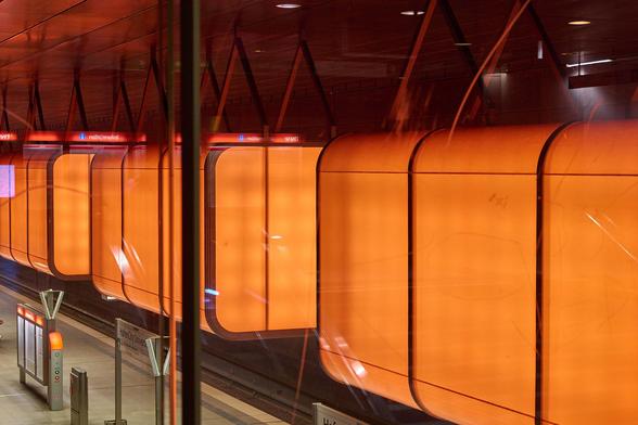 Blick auf die Deckenlampen einer U-Bahnstation. Im Moment der Aufnahme leuchteten die Lampen in orange.