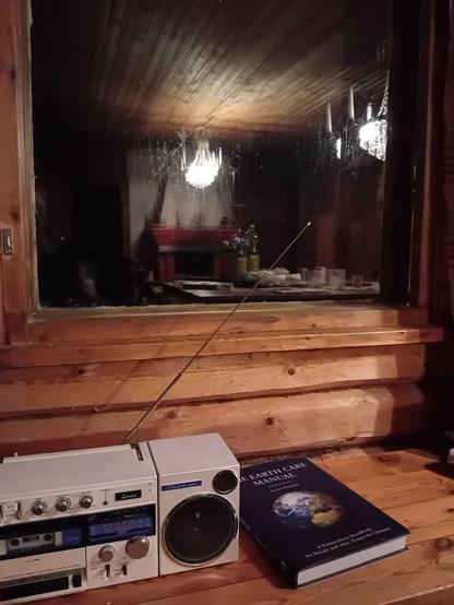 kasettiradio ja kirja pimeän ikkunan edessä