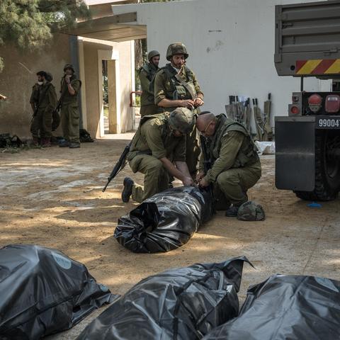 Israeli soldiers checking bodies in Kfar Aza, a village near Gaza, on Oct. 10, 2023.