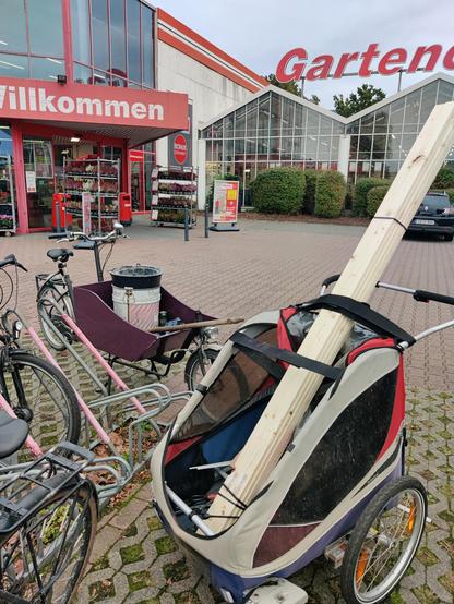 Sozusagen ein Bausatz: Ein Paket Holzlatten steht schräg in einem Fahrradanhänger.