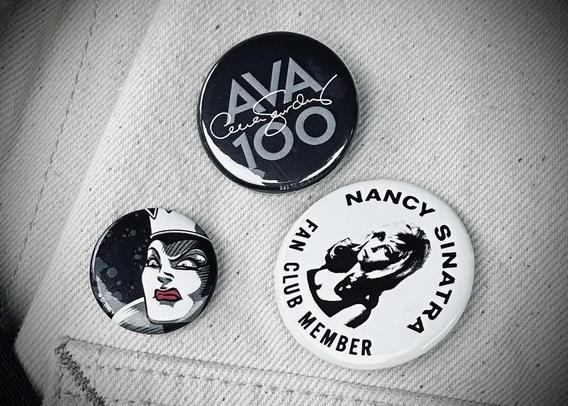 The pins on a jacket. Ava 100 Celebration, Nancy Sinatra Fan Club Member, Disney Evil Queen who is very Joan Crawford in this representation.