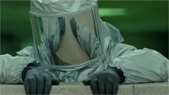 It's amazing how much money you can save on your movie shoot by having your hero wear a helmet that obscures their face and allows you to film an entire scene with a much cheaper stuntman!

Screenshot from the film 'The Minion' (2016)

The hero wearing a silver hazmat suit, grey gloves & a full-head helmet with mirrored glass (thus the face not visible) pulling himself up over a wall.