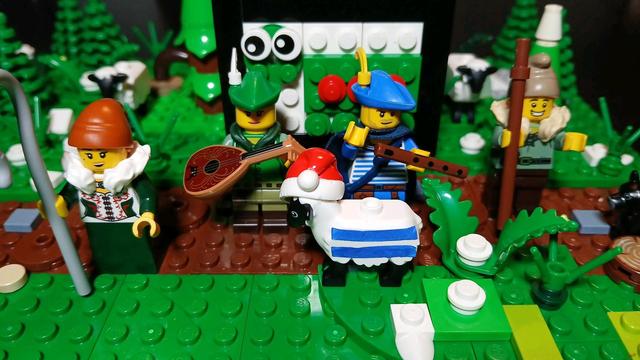 Des personnages Lego, une bergère, 2 musiciens et un berger. Avec un mouton rayé devant, avec un bonnet de Noël