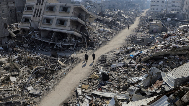 Palestinian people walking amongst the ruins of Gaza, the result of the relentless Israeli bombing and destruction of Gaza.