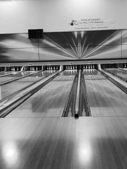A monochrome photo of a number of 5-pin bowling lanes.