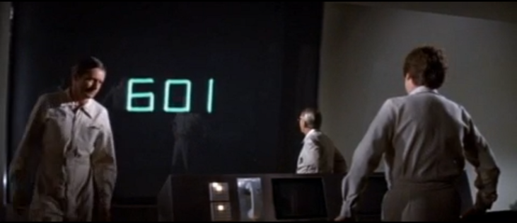 Picture from the movie "The Andromeda Strain" (1971)

On a large screen, "601" is written in green on a black background and three people are standing for it in different ways. One walks away from it, one looks eagerly at it and one stands behind the service for it.