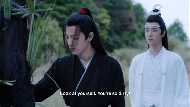 In an field of tall grasses abutting a forest, Wei Wuxian addresses Wen Ning, partially shown from behind at the left edge of the image, while Lan Wangji stands nearby:

Look at yourself. You're so dirty!