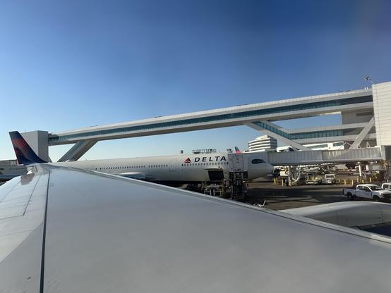 From a Delta Air Lines plane at SeaTac you see the wing and the International Sky Bridge.