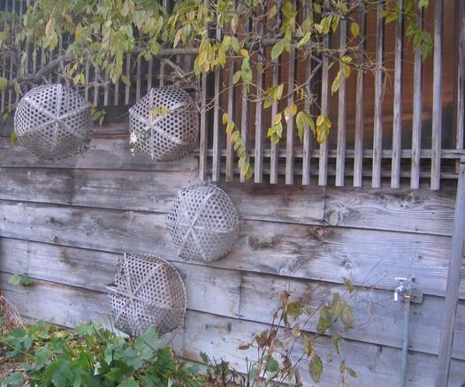 Reusen aus Bambus hängen nach getaner Arbeit an der hölzernen Wand.