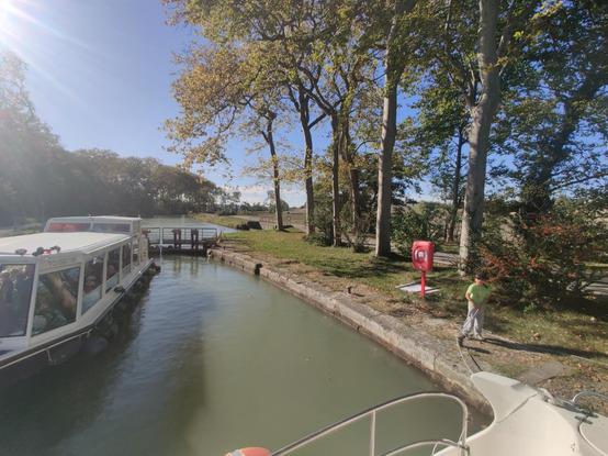 Schleusenbecken mit einem Ausflugsboot und herbstlichen Bäumen