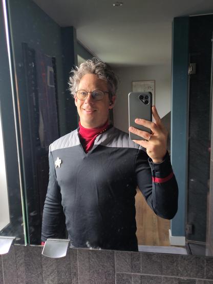 Ik voor de spiegel met een selfie. Star Trek Deep Space 9 uniform aan.

Het is heel goedkoop materiaal, dik en aan de binnenkant (dat zie je niet op de foto) valt het uit elkaar. Ik heb nog jeuk op de schouders en rug...
