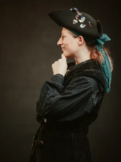side profile of starfish wearing a mostly black pirate outfit with a teal coloured bandana under the hat