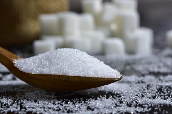 Cucharada de azúcar con terrones de fondo. (Getty Images)