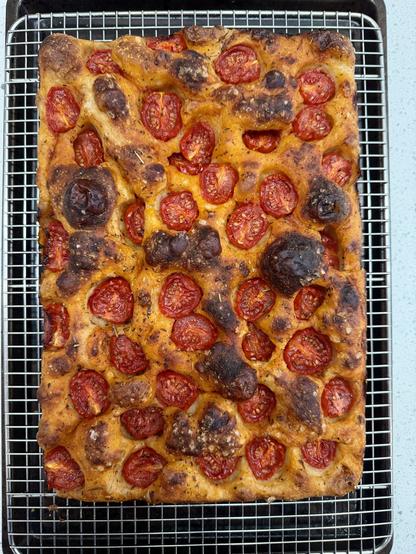 Baked tomato focaccia. The cherry tomatoes are more cooked down and the bubbles on the surface of the focaccia are nicely browned